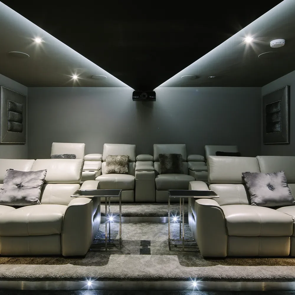 Bespoke cinema room with luxurious seating, projector and lighting design