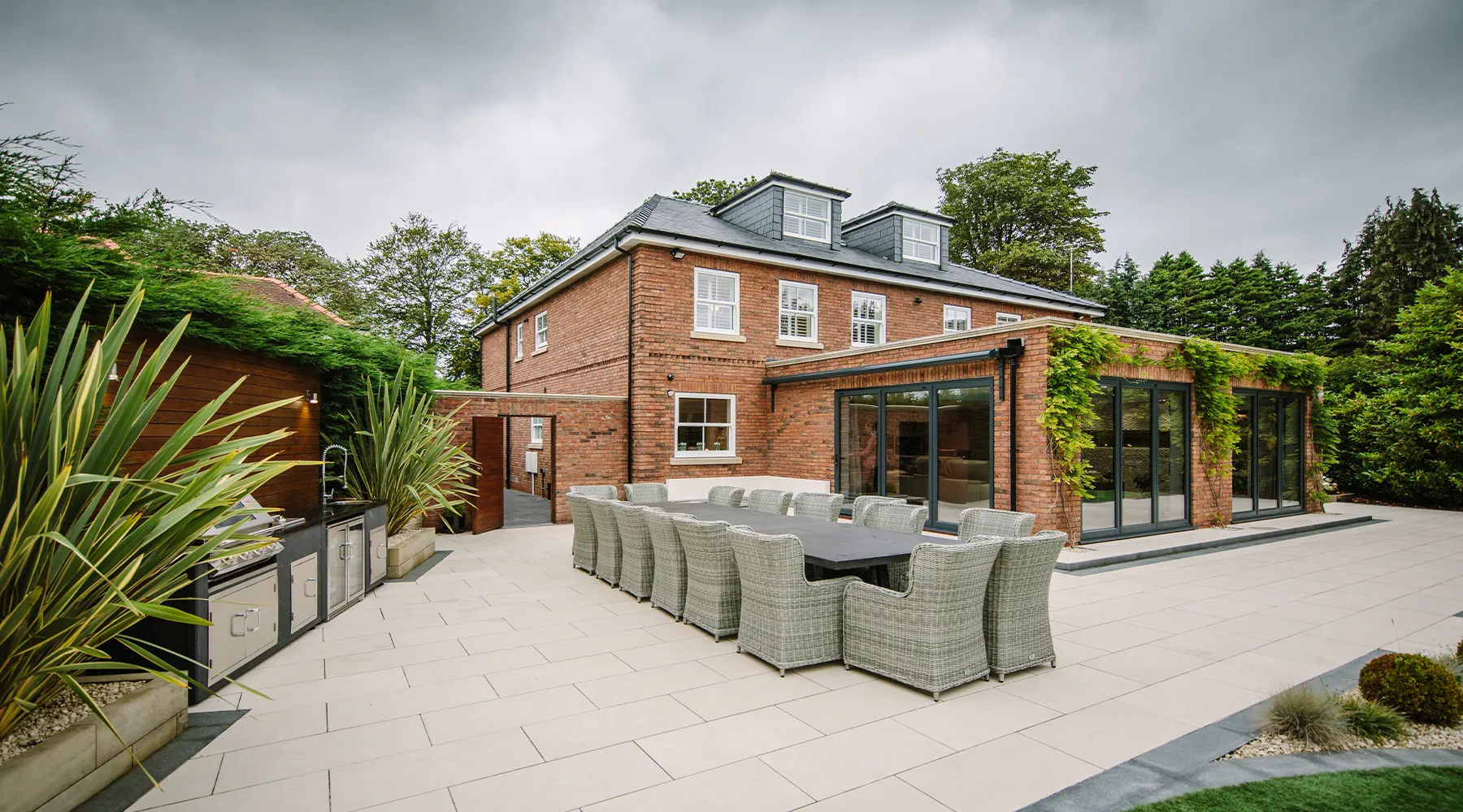 Elegant red-brick executive home with outdoor patio and kitchen with lighting and security by Majik House